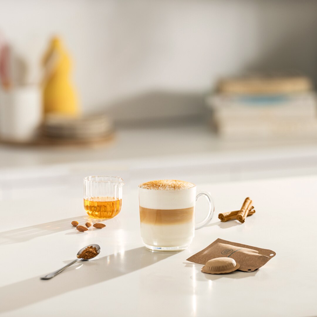 iced cappuccino next to a coffee capsule